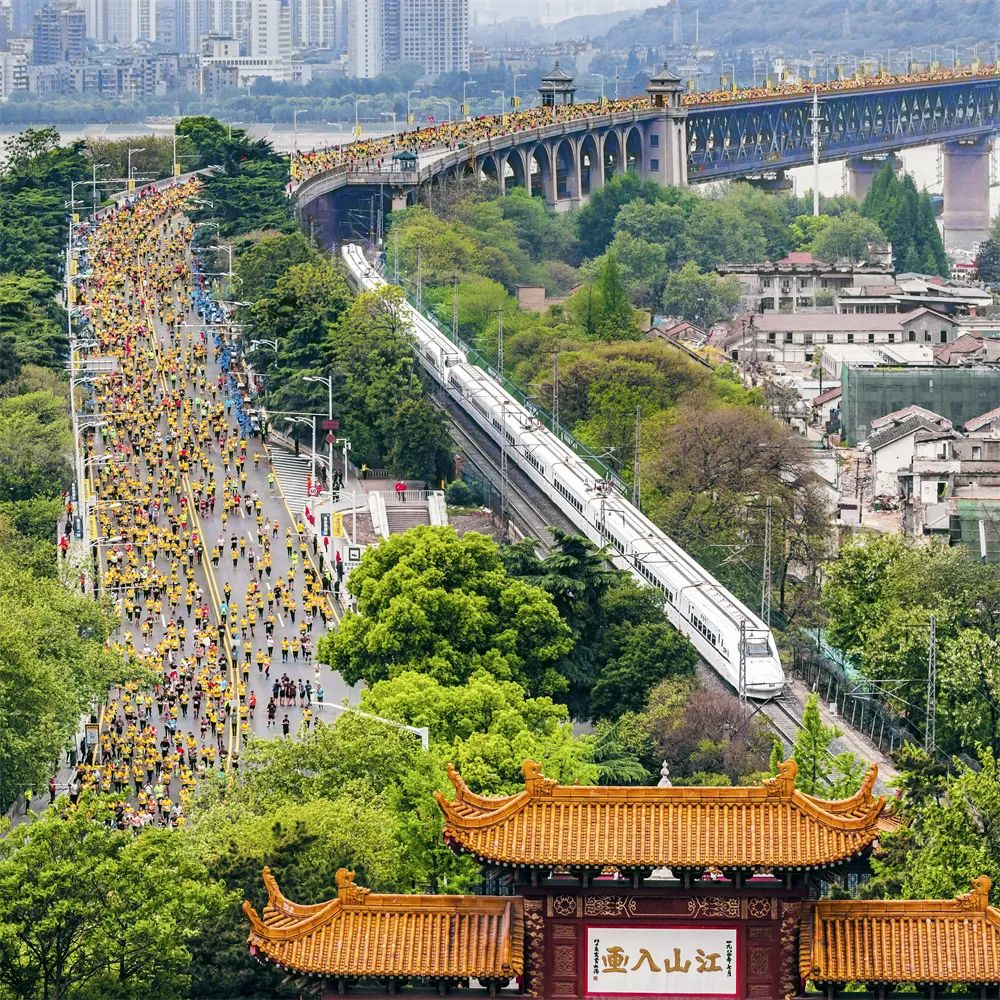齊頭并進(jìn) 姜濤 攝2019年4月14日，參加馬拉松比賽的選手們經(jīng)過武漢長江大橋，與動(dòng)車同行，與黃鶴樓同框。.jpg