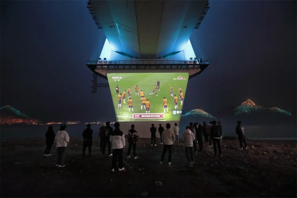 長江邊看“世界杯”   李亞隆 攝2022年11月27日，湖北宜昌夷陵長江大橋露天電影大屏前，一群年輕人就著冬日的江風(fēng)，觀看2022卡塔爾世界杯直播。.jpg